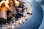 fire pit filled with lava rock, fire glass and driftwood logs