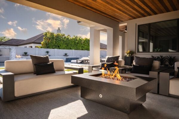 dark gray aluminum powder coated fire pit in a California backyard with a pool and luxury furniture