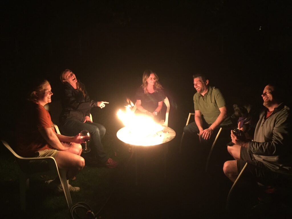 Family relaxing around a smokeless fire pit, enjoying connection and conversation at night.